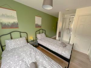 Perfect for contractors 2 bedroom- 2 bathrooms- 4 single beds- free parking في ساوثهامبتون: سريرين في غرفة بجدران خضراء
