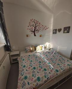 a bedroom with a bed with a tree on the wall at Apartmán Tony Slapy in Slapy