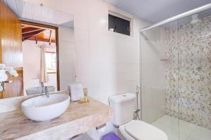 a bathroom with a sink and a toilet and a shower at Jardim Do Eden Piri in Pirenópolis