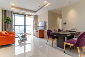 a living room with a table and purple chairs at The Rixx Spectacular Apartment @ Opera House-Hyatt in Ho Chi Minh City