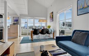 a living room with a blue couch and a table at Hummeren 164 in Ebeltoft