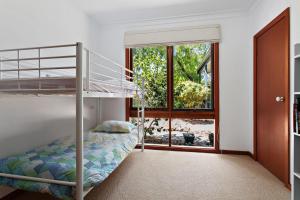 een slaapkamer met een stapelbed en een raam bij 1 Gordon St Cowes Kenros Beach House in Cowes
