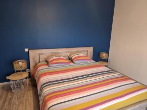 - une chambre avec un lit doté d'un couvre-lit rayé coloré dans l'établissement Gîte Pigerot, à Lucbardez-et-Bargues