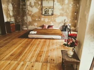 um quarto com uma cama e piso em madeira em Schöneberg Holiday Flat & Art Gallery em Berlim