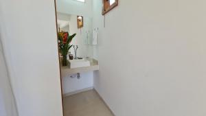 um banheiro com uma pia e um espelho em Piscina Aquecida, Jacuzzi, internet veloz, no centro de Serra Grande - Flat Céu - Vila Pitangueira em Serra Grande mais 11 fotografias