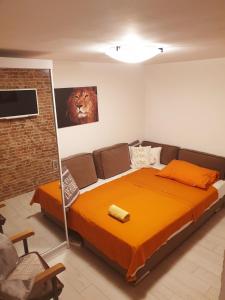 1 dormitorio con 1 cama grande con manta naranja en STUDIO APARTMAN "Daria", en Kostrena