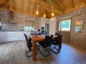 een keuken en eetkamer met een houten tafel en stoelen bij Casa Botica - Gerês Country House in Terras de Bouro