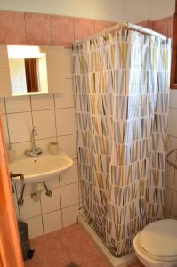 y baño con cortina de ducha y lavamanos. en Αndreas Studios en Ýpsos