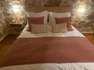 a large bed with red and white sheets and pillows at Posada de Lola in El Molar