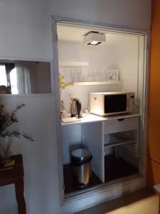 uma pequena cozinha com um micro-ondas e um lavatório em La casa deMarta em Córdoba