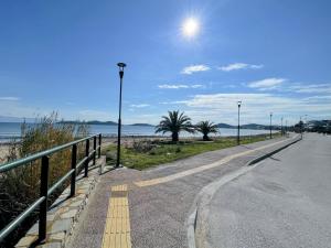 a walkway next to a beach with the ocean at Coastline Apartment in Nea Peramos +14 photos