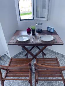 a table with two chairs and two plates on it at Coastline Apartment in Nea Peramos