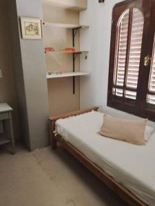 um pequeno quarto com uma cama e uma janela em La casa deMarta em Córdoba