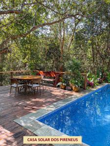 un patio con mesa y sillas junto a una piscina en Casas Solar dos Pireneus, en Pirenópolis