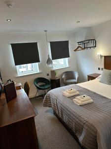 a bedroom with a bed with two towels on it at Nithsdale Hotel in Sanquhar +83 photos