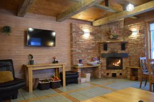 a living room with a brick wall with a fireplace at Lazdkalni in Ķimale