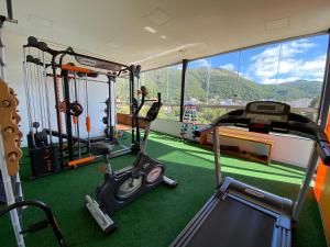 a gym with exercise equipment and a view of a mountain at Minas Garden Hotel in Poços de Caldas
