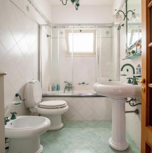 uma casa de banho branca com um WC e um lavatório em A casa tua Affitti brevi em Noto