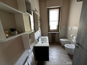 baño con lavabo y aseo y ventana en Grande appartamento panoramico, en Lu