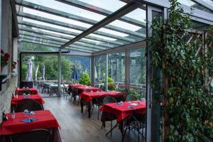 a restaurant with red tables and chairs in a greenhouse at Locanda Cà Priula in Albaredo per San Marco