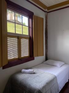 sypialnia z 2 łóżkami i oknem w obiekcie Casa Nossa Senhora do Carmo w mieście Ouro Preto