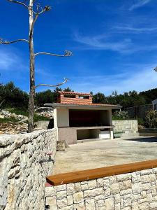 un edificio con un árbol y una pared de piedra en Villa Lucia with private pool and a whirlpool en Vis