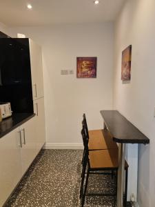 a kitchen with a table and a chair in a room at JAh LODGE BRSITOL BIG HOUSE FREE PARKING 20 PERCENT OFF WEEKLY MONTHLY STAY BUSINESS CONTRACTOR STUDENTS RELOCATIONS 5BED in Bristol