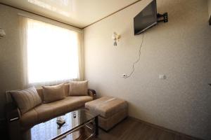 a living room with a couch and a tv on the wall at Oazis in Noratus