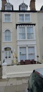 a large white building with chairs in front of it at St Davids & Moorfield Hotels Chapel Street in Llandudno