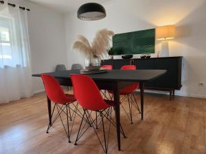 ラゴアにあるCozy Island Apartment II RAAL 2162のダイニングルームテーブル(赤い椅子、緑板付)