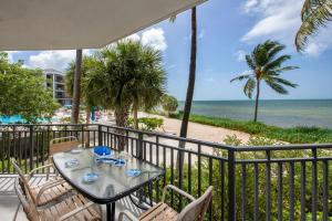 - stół i krzesła na balkonie z widokiem na plażę w obiekcie Mar Y Sol Ocean Front w mieście Key West