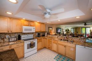 a kitchen with wooden cabinets and a ceiling fan at Mar Y Sol Ocean Front in Key West