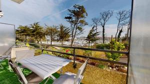 a table and chairs on a balcony with a view at Le Ponton Bleu vue face au Port in Saint-Gilles-Croix-de-Vie