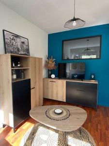 un salon avec une table et un mur bleu dans l'établissement Cosy F2 Royat Thermes, à Royat