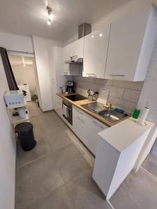 a small kitchen with white cabinets and a sink at Maison en centre-ville 