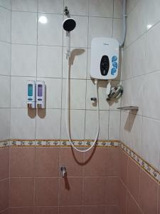 a shower in a bathroom with a shower head at AeCOTEL in Sandakan