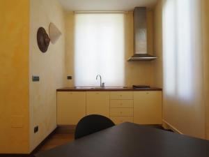cocina con mesa, fregadero y ventana en Music Home, en Macerata