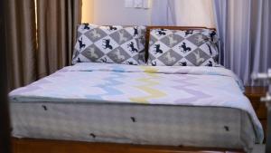 een bed met kussens in een slaapkamer bij Jeffston Court Apartments in Accra