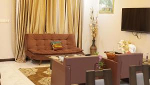 een woonkamer met een bank en een televisie bij Jeffston Court Apartments in Accra