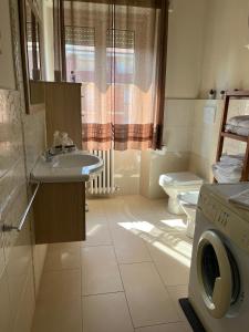a bathroom with a sink and a washing machine at stella marina in Lido di Fermo
