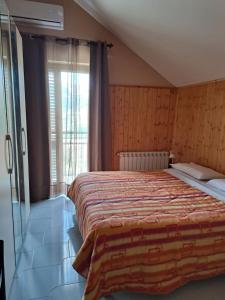 een slaapkamer met een groot bed en een groot raam bij Kairos B&B in San Giuseppe Iato