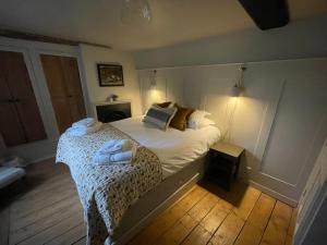 1 dormitorio con 1 cama con toallas en The Stag at Stow, en Stow on the Wold