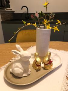 einen Teller mit einem Hasen und eine Vase mit Blumen in der Unterkunft Gîte Loufiosa Vannes in Vannes