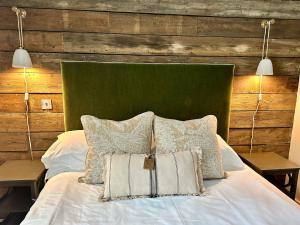 a bed with a green headboard and pillows on it at The Stag at Stow in Stow on the Wold