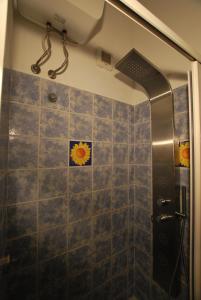 La salle de bains est pourvue d'une douche et d'un mur en carrelage. dans l'établissement Lipari Studio Old Town, à Lipari