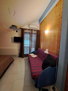 een woonkamer met een bank en een bed bij Kairos B&B in San Giuseppe Iato