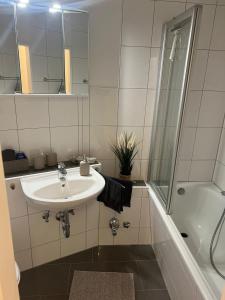 a white bathroom with a sink and a shower at Schleibude in Schleswig