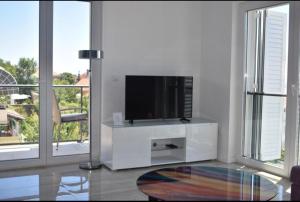 una sala de estar con TV en un centro de entretenimiento blanco en Apartments Marlin Blue en Dubrovnik