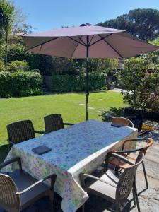 una mesa y sillas con una sombrilla en un patio en Quinta Drº Amarante en Gondomar