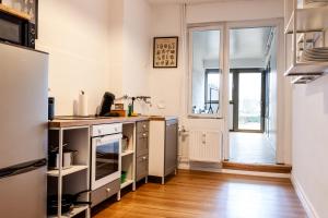 a kitchen with white walls and a wooden floor at Zentrales Apartment - 8 Boxspringbetten - Netflix in Kleve
